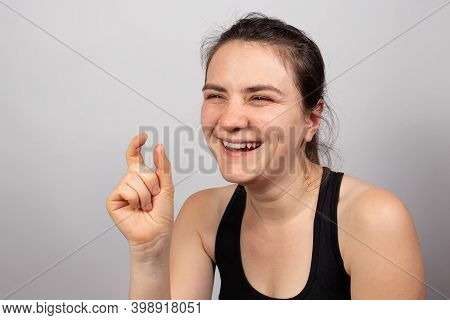 The Woman Laughs And Shows The Finger The Symbol Is Small. Small Salary, Small Credit, Small Size.