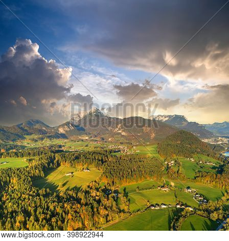 Aerial View Of Green Meadows With Villages And Forest In Austrian Alps Mountains.