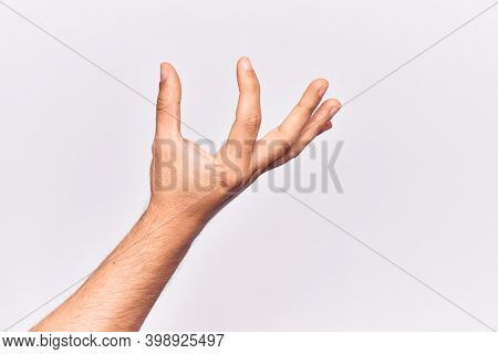 Close up of hand of young caucasian man over isolated background picking and taking invisible thing, holding object with fingers showing space 