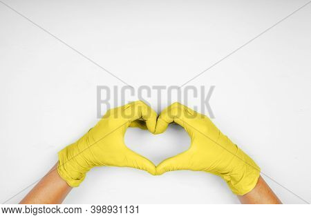 Hands In Yellow Heart-shaped Medecine Gloves On Gray Background