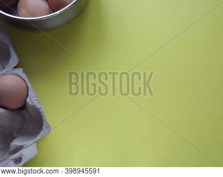 Beige Boiled Eggs In A Pot Of Water With An Egg Box On A Gray Background. High Quality Photo