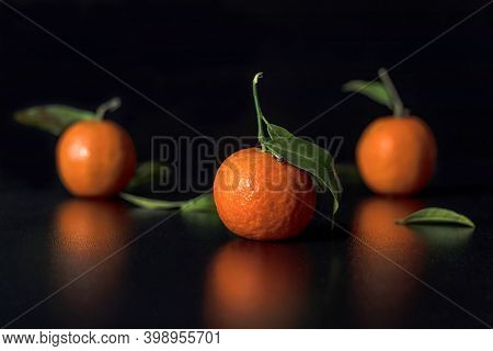 Fresh Tangerine With Leavers Lies On A Black Table In The Black Background. Selective Focus. New Yea