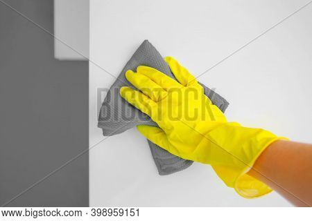A Female Hand In Yellow Rubber Gloves Wipes A Modern White Kitchen With A Microfiber Cloth. Color Of