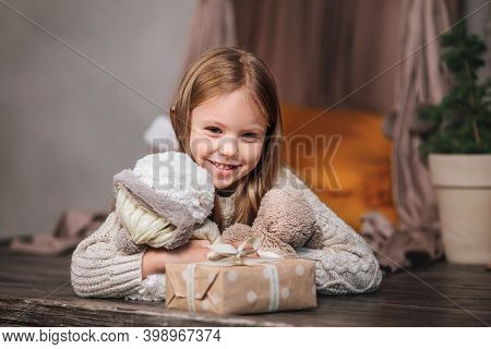 Cutre Little Girl Lying Among Christmas Gifts At Home .