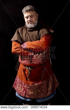 Mature Bearded Man In Traditional Medieval Historic Clothes Studio Portrait.