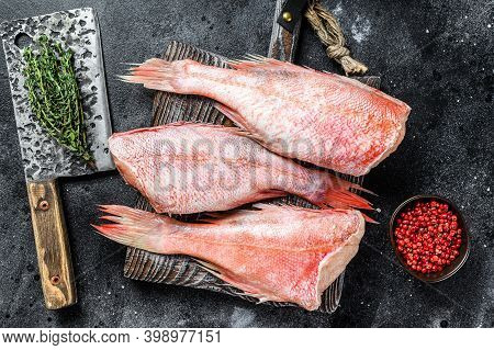 Whole Raw Red Snapper Fish On A Cutting Board. Black Background. Top View