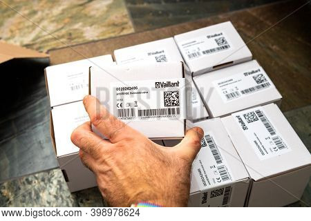 Paris, France - Oct 25, 2020: Pov Male Hand Holding Package Above Multiple Vaillant Ambisense Vr50 T