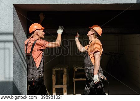Workers Are Installing Lift Gates In The Garage.