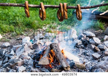 Gernan brezels on a stick over fire