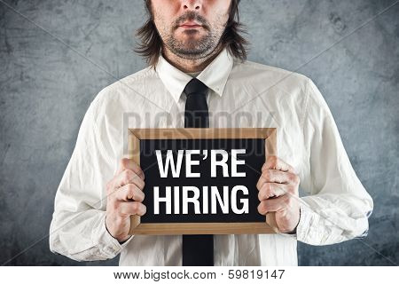 Businessman Holding Blackboard With We Are Hiring Title