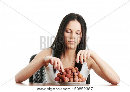 Young beautiful caucasian woman eating litchi fruits, isolated on whiet background