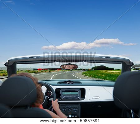 Woman driving a car on the paved country road