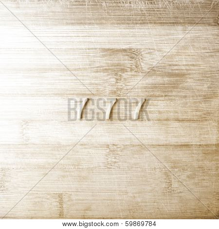 Three sevens on a wooden background in sepia