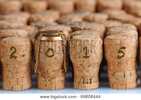 Closeup of a large group of Champagne corks, that fill the frame with the date 2015. Selective focus on the front row. One cork has the metal cage. Horizontal format.