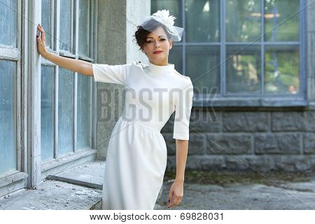 Wedding. Beautiful woman in stylish sheath dress on a background of old building.