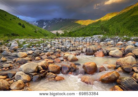 Summer landscape with the mountain river. Black clouds over a mountain valley. Zemo Svaneti, Georgia