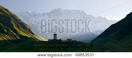 Panorama Caucasus Mountains. Stone medieval church in a mountain valley. View of Mount Shhara. Ushguli community, Zemo Svaneti, Georgia