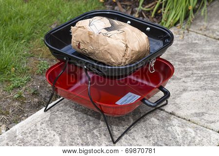 Portable BBQ with unlit instant charcoal.