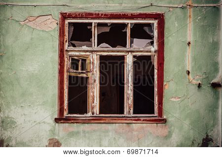 Smashed Glass Window With Old Wooden Frame On Grunge Wall Damaged House