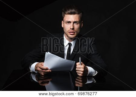 Handsome young man in suit on dark background