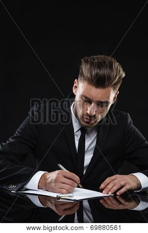 Handsome young man in suit on dark background