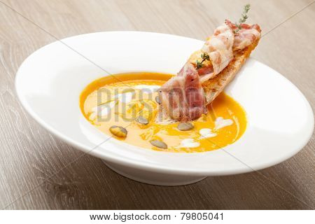Pumpkin Cream Soup Purée With Bread Slice, Bacon And Seeds