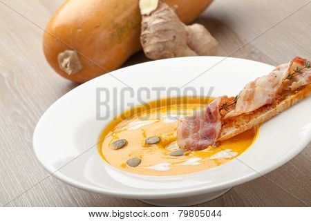 Pumpkin Cream Soup Purée With Bread Slice, Bacon And Seeds
