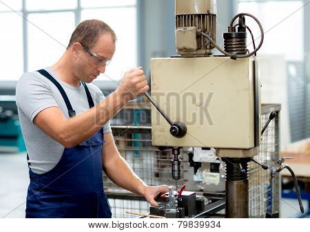 worker in factory using drill machine