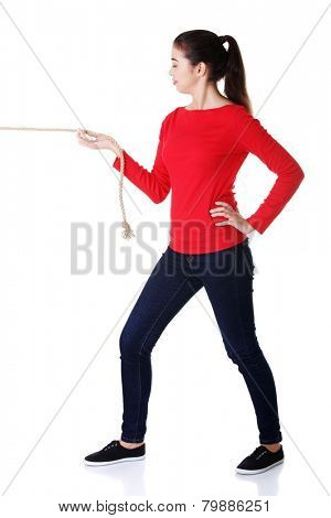 Full length strong woman puling rope.