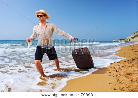 Un touriste transportant une valise à la plage Peroulades à l'île de Corfou