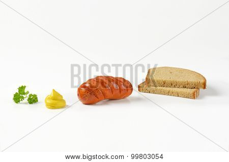 roasted sausage, mustard and bread slices on white background