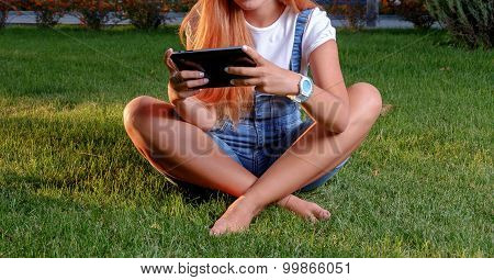 Young woman enjoying her time in park with tablet computer