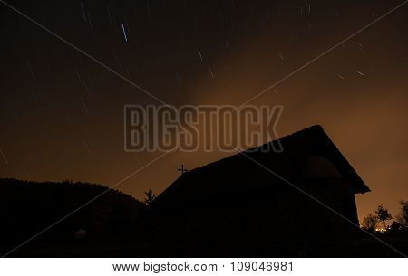 Christian Church In Silhouette During A Starry Night And Orange Sky