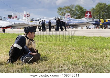 Man In Vintage Pilot Uniform Smiling With The Swiss Pilatus Aerobatic Team P3 Flyers In Background