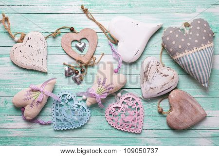 Different Decorative  Hearts On Turquoise Painted Wooden Background.