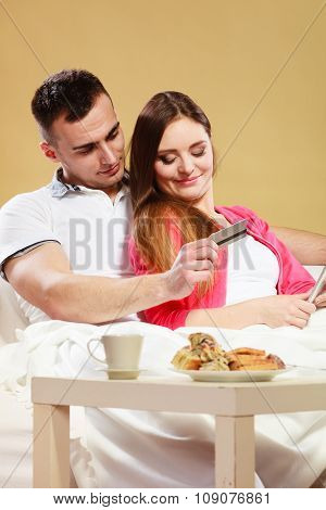 Young Couple With Tablet And Credit Card At Home