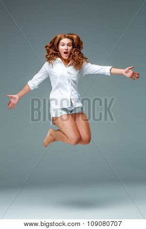 Beautiful jumping girl isolated on blue background
