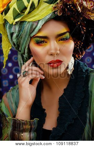 beauty bright woman with creative make up, many shawls on head like cubian woman, ethno look