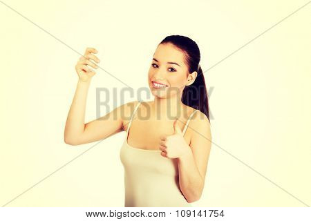 Young smiling woman with anti perspirant and thumbs up.