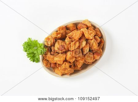 plate of salty pork greaves on white background