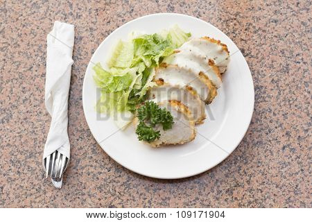Sliced chicken cordon bleu with creamy sauce and romane leaf salad