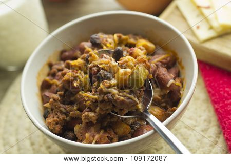 Hot and spicy Chili con carne with a glass of milk and pepper jack cheese