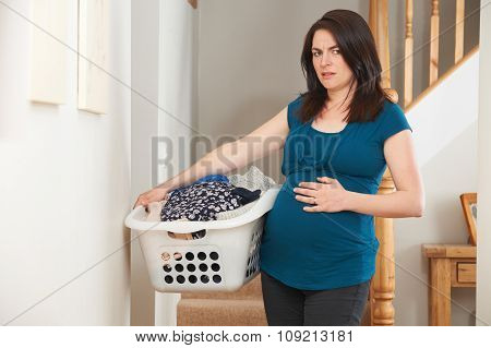 Stressed Pregnant Woman Doing Chores At Home