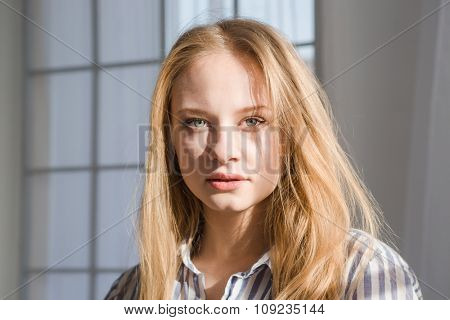 Portrait of attractive sensual young female with blonde hair in striped pajamas