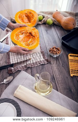 Woman in kitchen making prepares a pie with pumpkin, selective focus