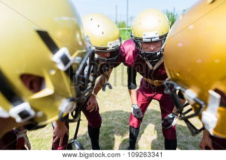 American Football players at strategy huddle