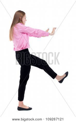 back view of business woman pushes wall.  Isolated over white background. Rear view people collection. backside view of person. Woman office worker in a pink shirt repels someone hands and feet.