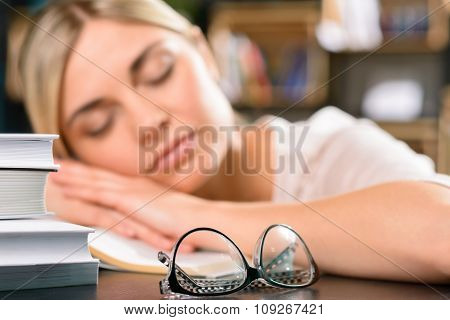 Young girl is asleep on the desk.
