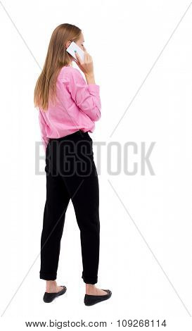 back view of woman talking on the phone.  backside view of person.  Rear view people collection. Isolated over white background. girl office worker in black trousers talking on smartphone looks right.