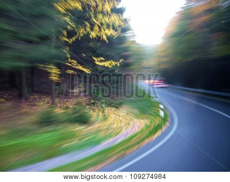 Road  through wood with artistic motion blur - turning left